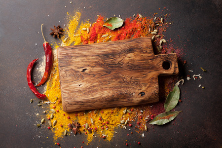 Various spices spoons and cutting board on stone table. Top view with copy spaceの写真素材