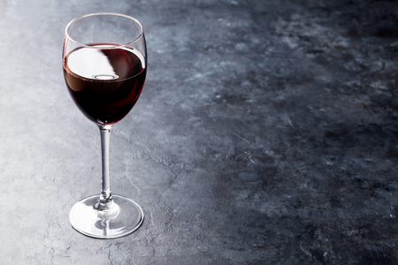 Red wine glass on stone table. With copy spaceの写真素材