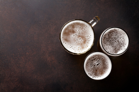 Lager beer mugs on stone table. Top view with copy spaceの写真素材