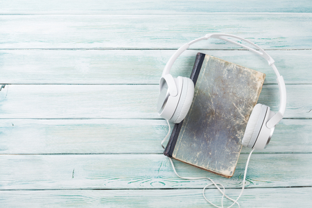 Audio book concept. Headphones and old books over wooden table. Top view with space for your textの写真素材