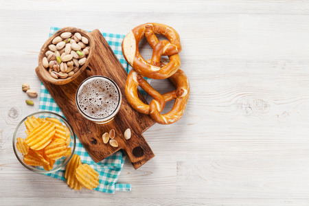 Lager beer and snacks on wooden table. Nuts, chips, pretzel. Top view with copy spaceの写真素材