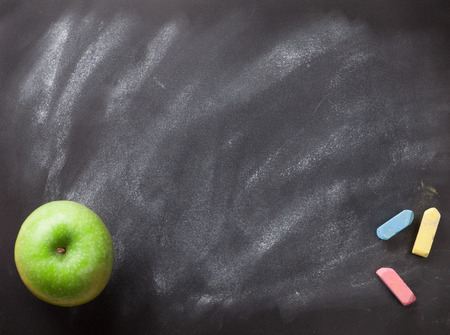 Green apple on blackboard or chalkboard background. Back to school concept. Top view with copy spaceの写真素材