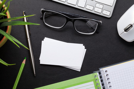 Office desk with computer and supplies. Blank business cards. Top view with space for your textの写真素材