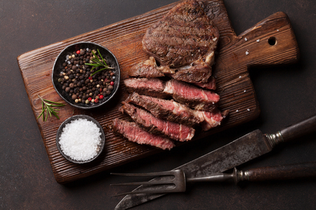 Grilled beef steak with spices on cutting board. Top viewの写真素材