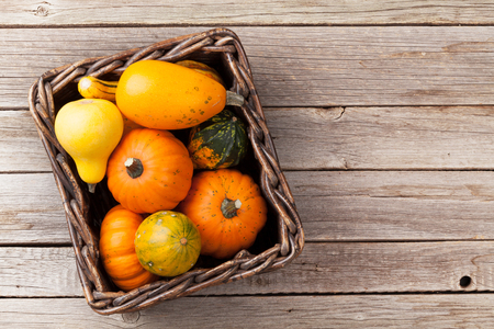 Autumn pumpkins in box on wooden table. Top view with copy spaceの写真素材