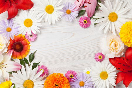 Garden flowers frame on wooden background. Top view with copy spaceの写真素材