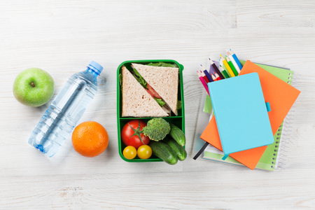 Lunch box with vegetables and sandwich on wooden table. Kids take away food box. Top viewの写真素材