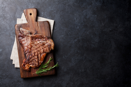 Grilled T-bone steak on stone table. Top view with copy spaceの写真素材