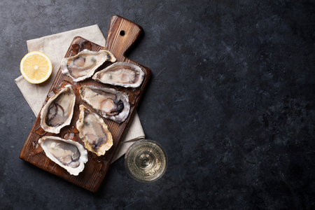 Opened oysters, ice and lemon on board. Top view with copy spaceの写真素材