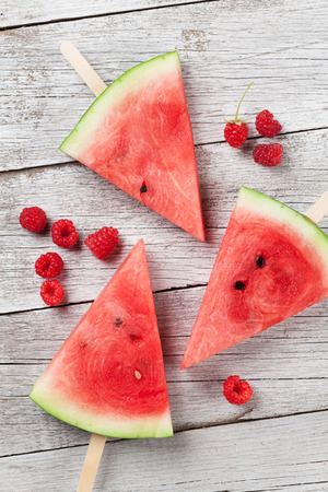 Fresh watermelon slices and berries on wooden background. Top viewの写真素材
