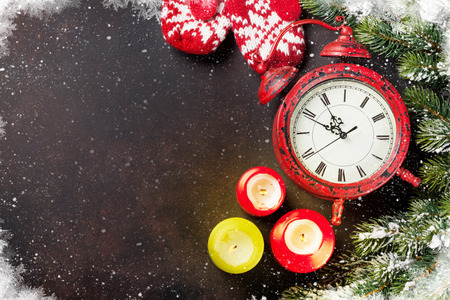 Xmas greeting card. Christmas background with snow fir tree, mittens and alarm clock. View from above with space for your greetingsの写真素材
