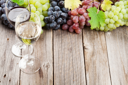 Wine glasses and grapes on wooden table. With space for your textの写真素材