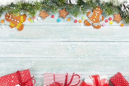 Xmas greeting card. Christmas background with snow fir tree and gingerbread cookies. View from above...