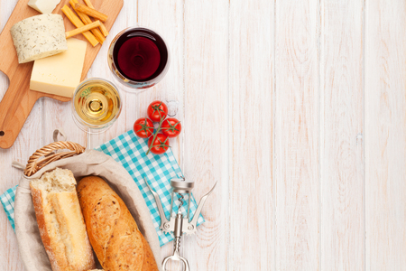 White and red wine, cheese and bread on white wooden table background. Top view with copy spaceの写真素材