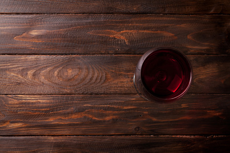 Red wine glass on wooden table. Top view with space for your textの写真素材