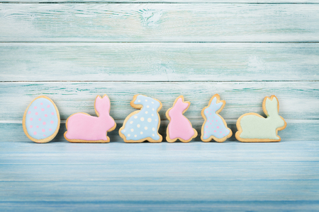 Easter gingerbread cookies in front of wooden wall. With space for your greetings