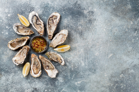 Fresh oysters on stone table. Top view with space for your text