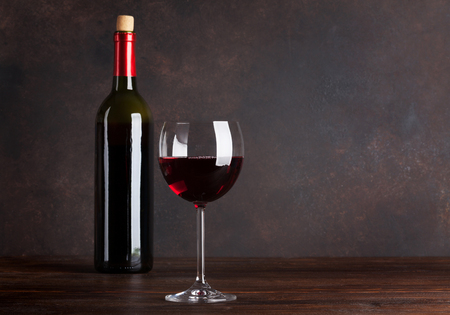 Red wine bottle and glass in front of blackboard wall. With copy space for your textの写真素材
