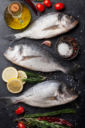 Raw dorado fish with spices cooking on cutting board. Top viewの写真素材