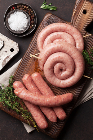 Raw sausages cooking on wooden cutting board. Top viewの写真素材