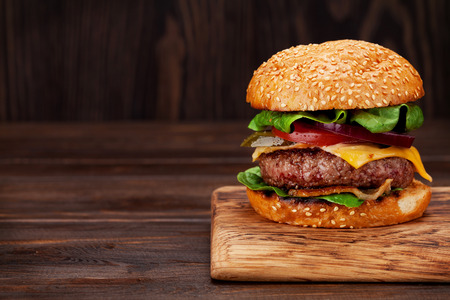 Tasty grilled home made burger with beef, tomato, cheese, cucumber and lettuce. With copy spaceの写真素材