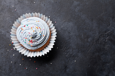 Sweet cupcake with colorful decor. Top view with space for your greetingsの写真素材