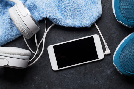 Fitness concept with sneakers, smartphone, towel and headphones. Top view with copy spaceの写真素材
