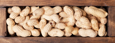 Peanut nuts in wooden box. Top view