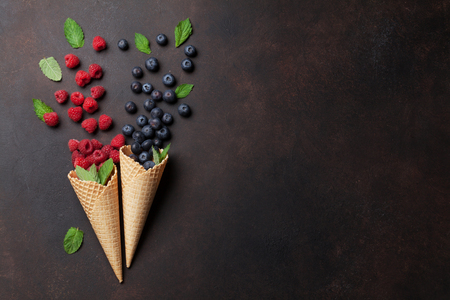 Ice cream cones with berries. Top view with space for your textの写真素材