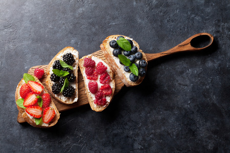 Brushetta or traditional spanish tapas with various berries. Appetizers italian antipasti snacks...