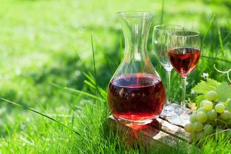 Rose wine in decanter and glasses and grapes. Outdoor in the vineyard. With space for your textの写真素材