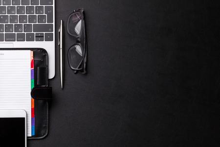 Office workplace table with supplies, smartphone and laptop. Flat lay. Top view with space for your...