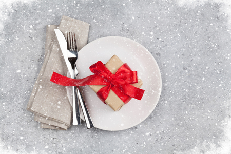 Christmas or Valentines day table setting with gift box on stone background. Top view with space for your greetingsの写真素材