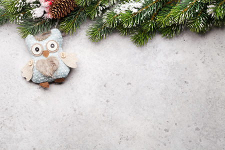 Christmas greeting card with decor and fir tree branch covered by snow on stone backdrop. Top view with space for your greetingsの写真素材