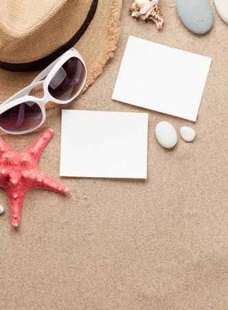 Travel vacation background concept with sunglasses, beach hat, seashells and photo frames on sand backdrop. Top view with copy space. Flat layの写真素材