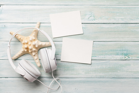 Travel vacation and music concept with headphones, starfish and photo frames on wooden backdrop. Top view with copy space. Flat layの写真素材