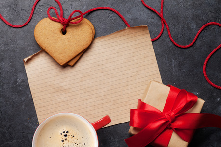 Valentine's day greeting card with coffee cup and heart shaped cookies on stone background. Top view with space for your greetings. Flat layの写真素材