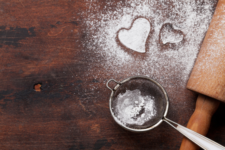 Valentine's day greeting card with cooking heart shaped cookies on wooden background. Top view with space for your greetings. Flat layの写真素材