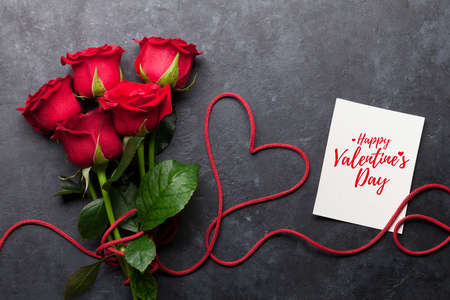 Valentine's day greeting card with red rose flowers bouquet on stone background. Top viewの写真素材