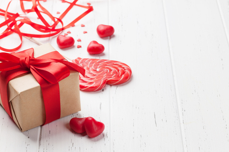Valentine's day greeting card with heart candy and gift box on wooden background. With space for your greetingsの写真素材