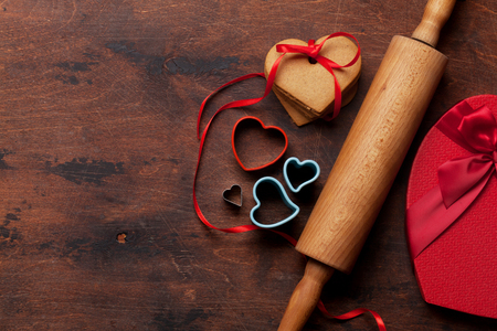 Valentine's day greeting card with cooking heart shaped cookies on wooden background. Top view with space for your greetings. Flat layの写真素材