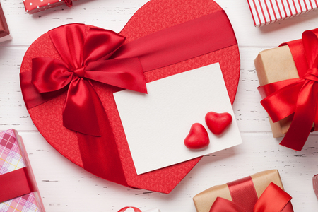Valentine's day greeting card with heart gift boxes on wooden background. Top view with space for your greetings. Flat layの写真素材