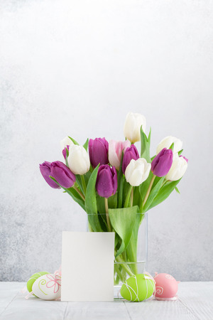Easter greeting card with tulip flowers bouquet and easter eggs. With space for your greetingsの写真素材