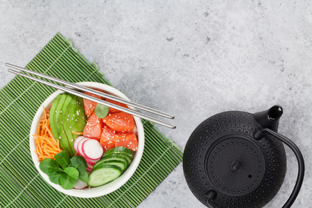 Poke bowl with salmon and vegetables. Traditional Hawaiian raw fish salad. Top view with copy spaceの写真素材