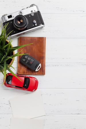 Travel vacation concept with camera, passport, car toy and photo frames on wooden backdrop. Top view with copy space. Flat layの写真素材