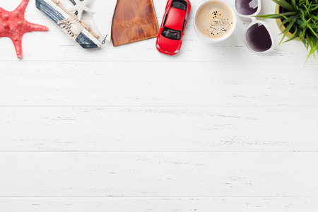 Travel vacation background concept with sun hat, sunglasses, passport, car toy and starfish on wooden backdrop. Top view with copy space. Flat layの写真素材