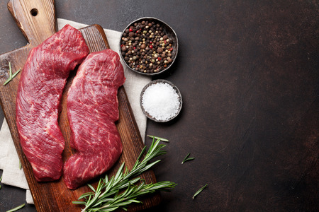 Raw top blade or denver steak cooking on cutting board cooking. Top view with copy spaceの写真素材