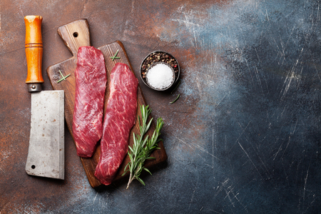 Raw top blade or denver steak cooking on cutting board cooking. Top view with copy spaceの写真素材