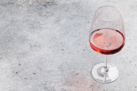 Rose wine glass on stone backdrop. With space for your textの写真素材