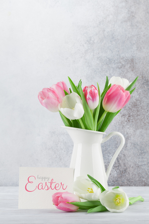 Easter greeting card with tulip flowers bouquet. In front of stone wall with space for your greetingsの写真素材